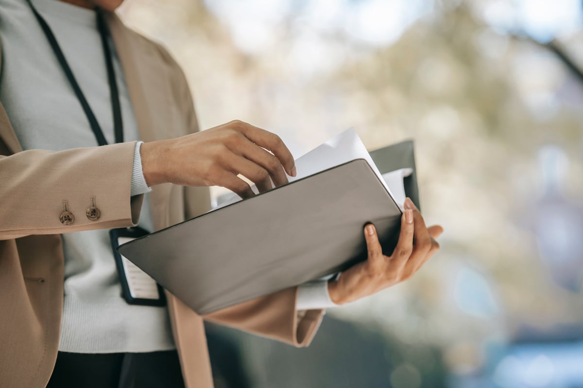 Crop businesswoman with folder with documents