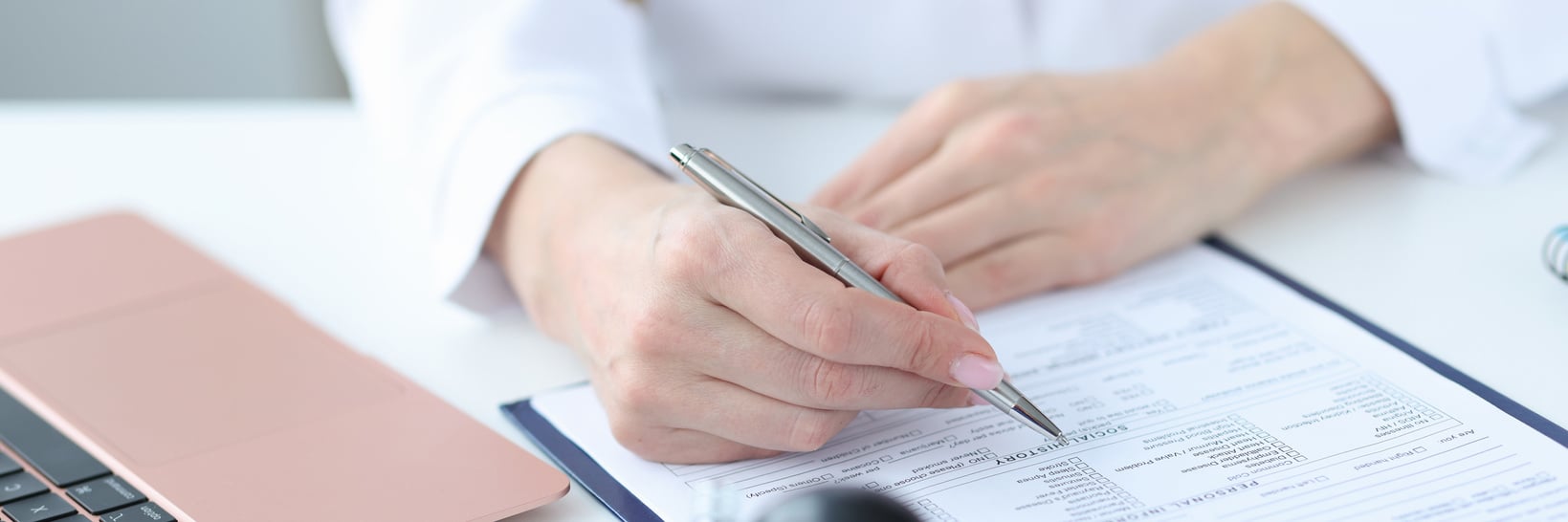 Doctor Filling Out Patients Medical History in Clinic Closeup