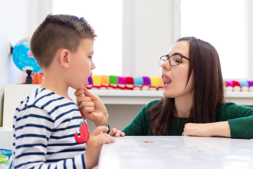 Children speech therapy concept. Preschooler practicing correct pronunciation with a female speech therapist.